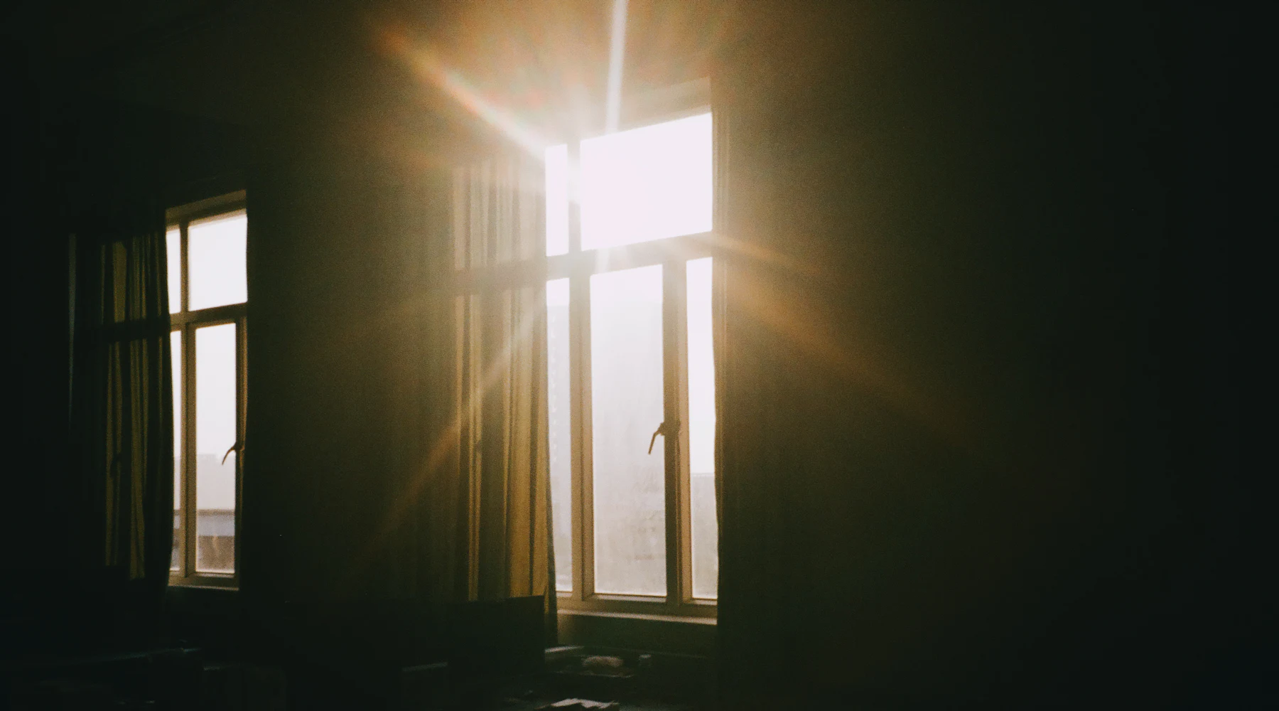La lumière du jour qui entre par une fenêtre dans une pièce sombre