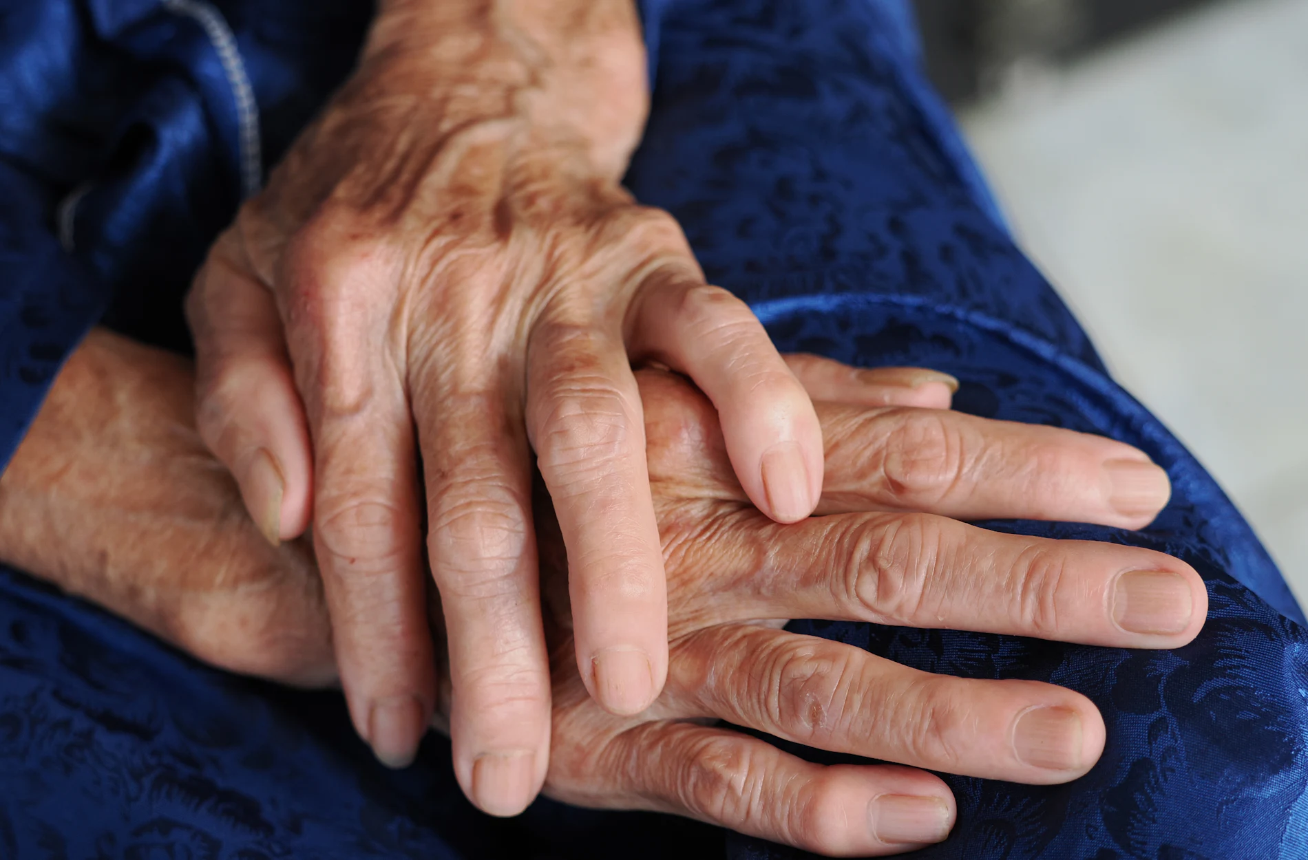 Deux mains qui se tiennent, l'une plus âgée que l'autre